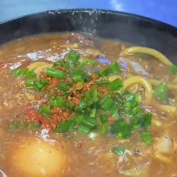 Lomi noodle soup with egg, spring onion and toasted garlic