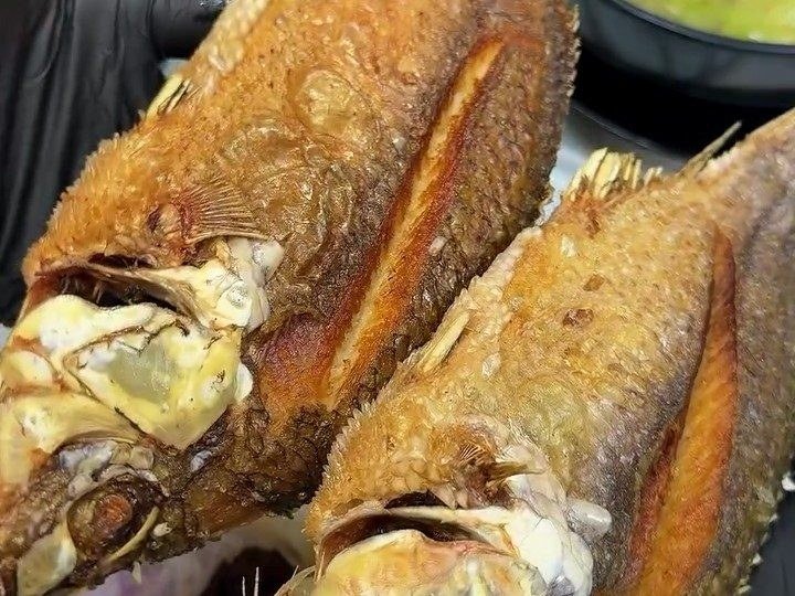 Two whole fried fish straight from the fryer, the plate kamayan was made for