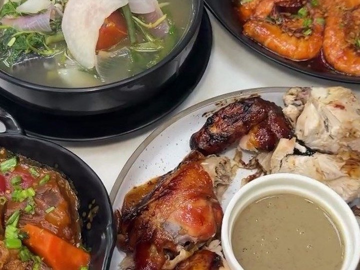 Grilled chicken pieces with a dipping sauce on a table spread