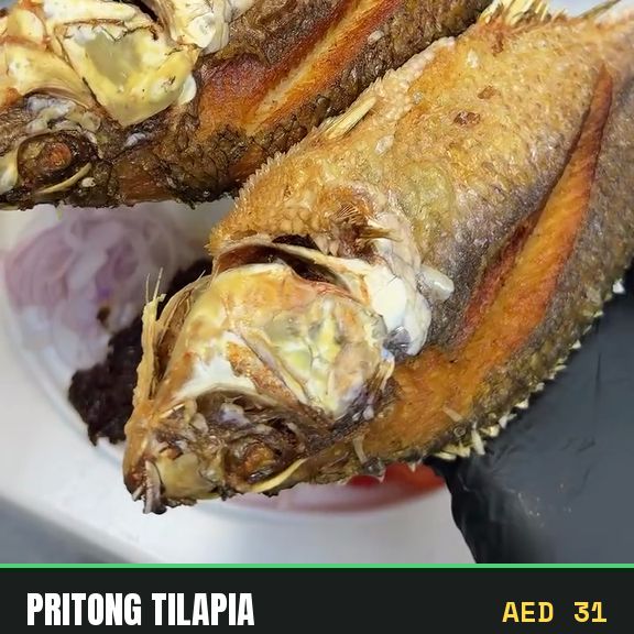 Pritong tilapia, fried whole and served with tomatoes and bagoong