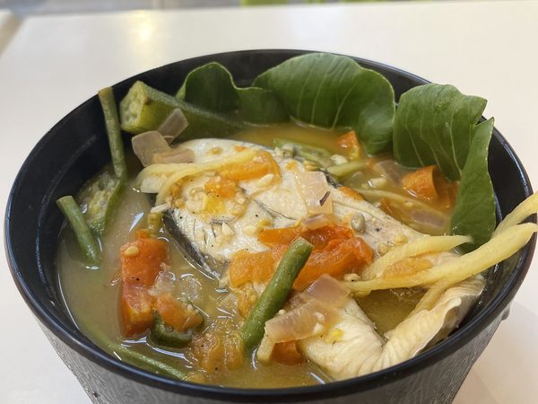 Bowl of sinigang na isda, fish in sour broth with okra, long beans, tomato, carrot and pechay