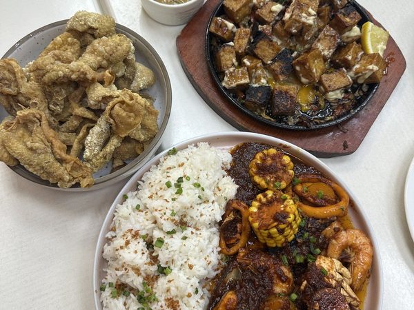 Overhead spread of crispy chicharon bulaklak, sizzling tofu with lemon, and a seafood platter of crab, squid and prawns in chilli sauce with garlic rice