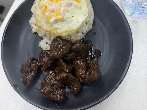 Tapsilog plate of sweet beef tapa with garlic fried rice and a sunny side up egg.