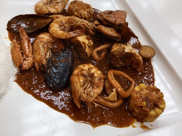 Seafood platter of prawns, crab claws, mussels, squid rings, corn on the cob and potato in a thick garlic-butter sauce with steamed rice
