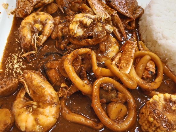 Generous seafood boil of crab, prawns, squid rings, mussels, corn and potatoes in a thick spicy sauce, served with a scoop of steamed rice